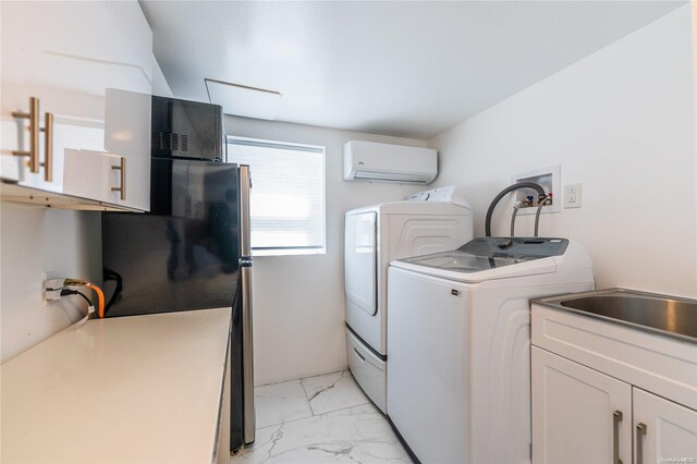 laundry room featuring cabinets, a wall unit AC, and washing machine and clothes dryer