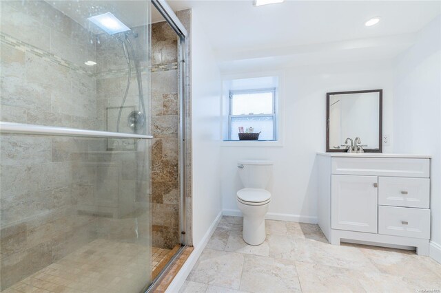 bathroom featuring a shower with door, vanity, and toilet