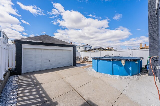 view of swimming pool featuring an outdoor structure and a garage