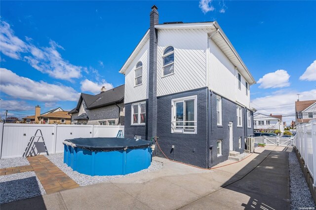 back of house featuring a covered pool