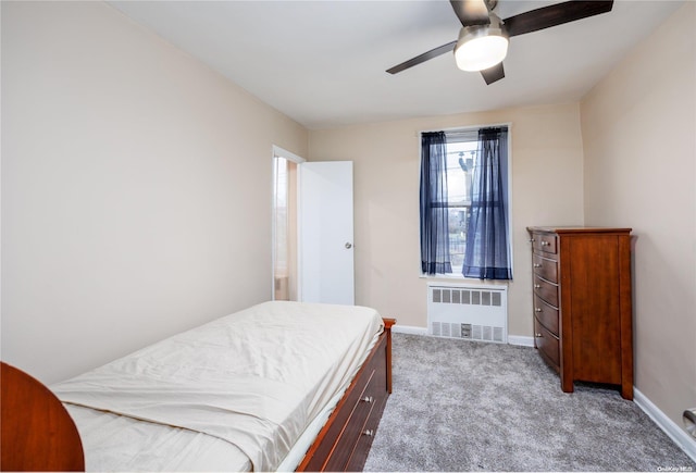 bedroom with ceiling fan, light colored carpet, and radiator