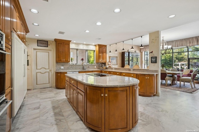 kitchen with stainless steel oven, an inviting chandelier, kitchen peninsula, decorative light fixtures, and decorative backsplash