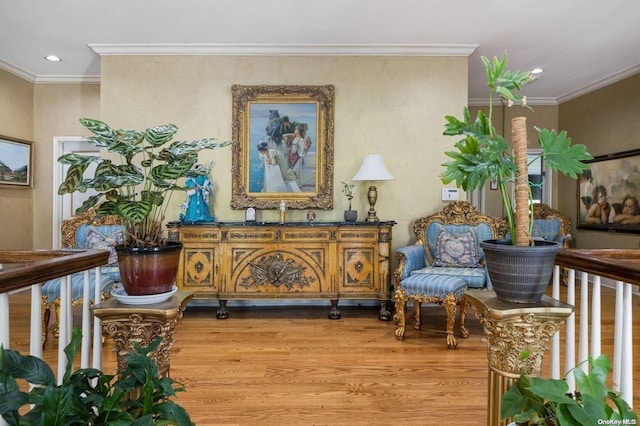 living area with wood-type flooring and ornamental molding