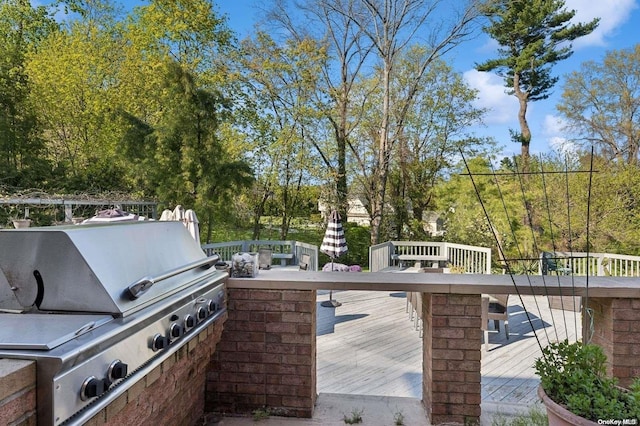 view of patio with grilling area and a wooden deck