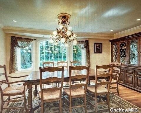 dining area featuring hardwood / wood-style floors, crown molding, and a chandelier