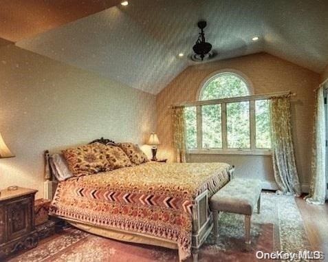 bedroom featuring vaulted ceiling and hardwood / wood-style flooring