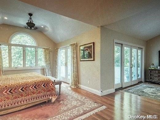 bedroom with hardwood / wood-style flooring, access to exterior, french doors, and vaulted ceiling