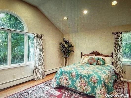 bedroom featuring hardwood / wood-style flooring and lofted ceiling