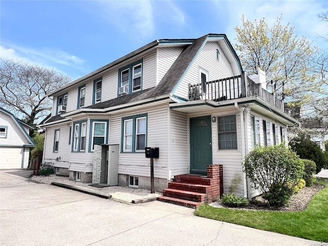 view of front of home featuring cooling unit, a balcony, and an outdoor structure