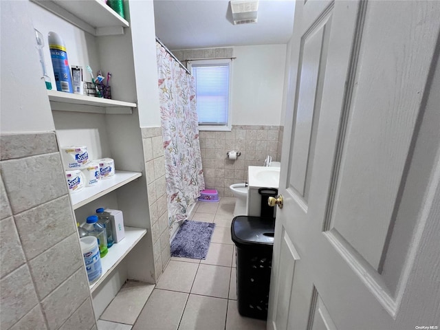 bathroom with tile patterned flooring, toilet, and tile walls