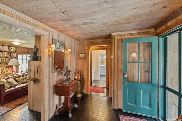 foyer entrance with wood walls, dark hardwood / wood-style flooring, wooden ceiling, and ornamental molding