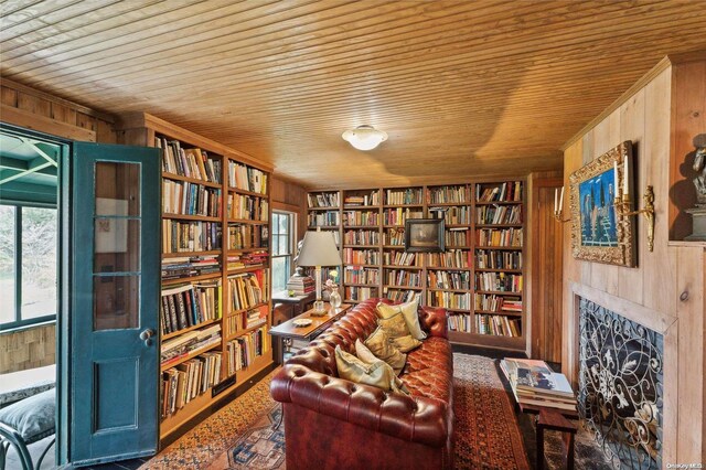 living area with wooden ceiling and wood walls