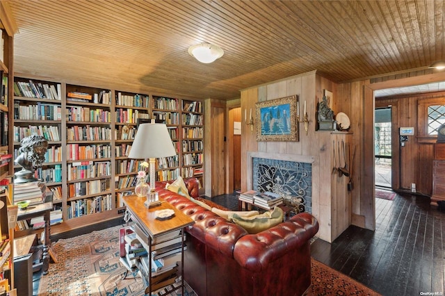 living area with wooden walls, built in features, wooden ceiling, and dark hardwood / wood-style floors