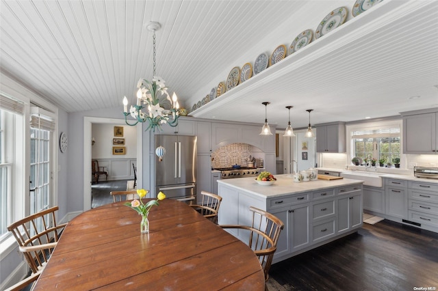 dining space featuring dark hardwood / wood-style floors, vaulted ceiling, a notable chandelier, and sink