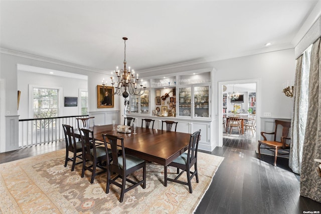 dining space featuring dark hardwood / wood-style floors, ornamental molding, and a chandelier