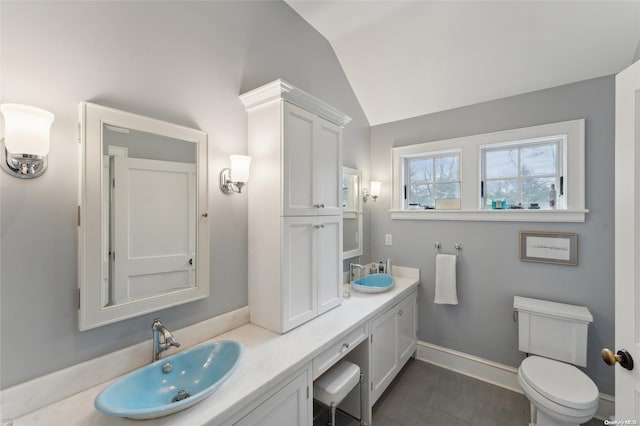 bathroom with tile patterned floors, vanity, vaulted ceiling, and toilet