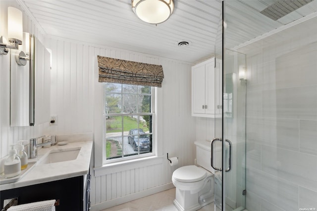 bathroom with vanity, toilet, and a shower with shower door