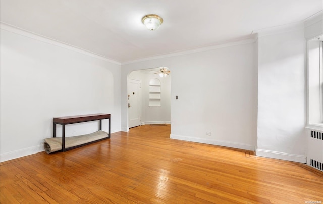 spare room with crown molding, radiator heating unit, ceiling fan, and light hardwood / wood-style floors