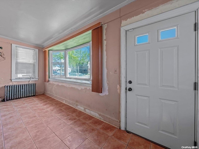 doorway to outside featuring radiator heating unit, ornamental molding, and light tile patterned floors