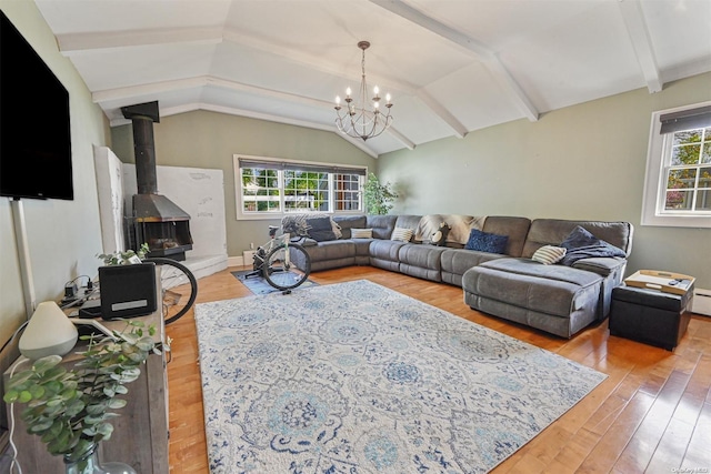 living room with a wood stove, plenty of natural light, vaulted ceiling with beams, and hardwood / wood-style flooring