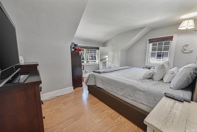 bedroom featuring light hardwood / wood-style flooring and vaulted ceiling