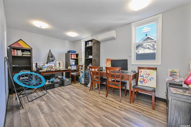 office space with a wall unit AC and light hardwood / wood-style flooring