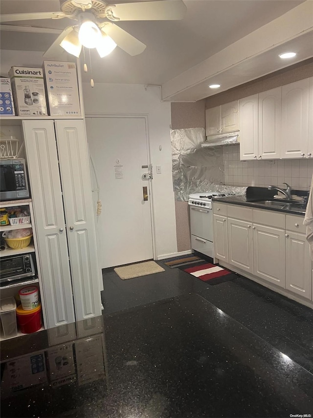 kitchen with backsplash, white cabinets, sink, ceiling fan, and white range with gas cooktop