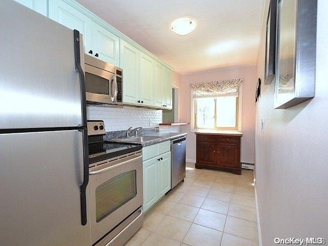 kitchen featuring white cabinetry, decorative backsplash, sink, and stainless steel appliances