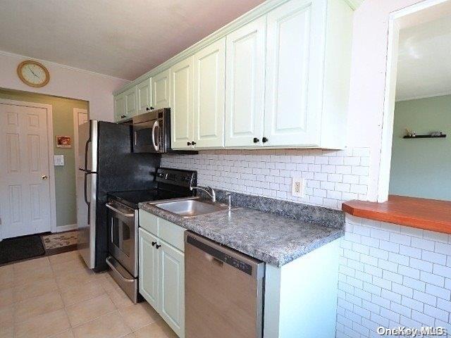 kitchen with decorative backsplash, white cabinetry, sink, and appliances with stainless steel finishes