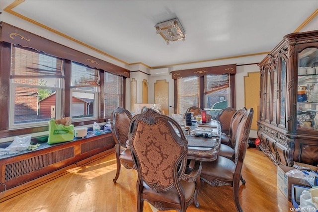 dining area featuring ornamental molding and light hardwood / wood-style flooring