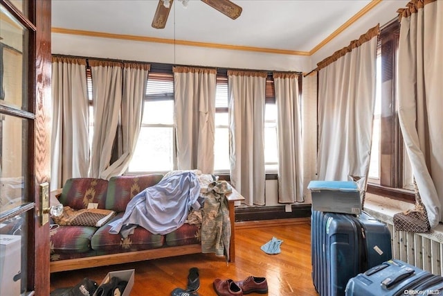 bedroom featuring hardwood / wood-style flooring, ceiling fan, and ornamental molding