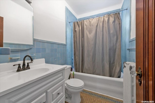 full bathroom featuring vanity, shower / bath combination with curtain, toilet, and tile walls