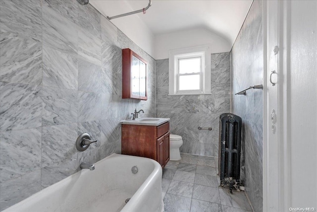 bathroom with vanity, lofted ceiling, toilet, tile walls, and radiator heating unit