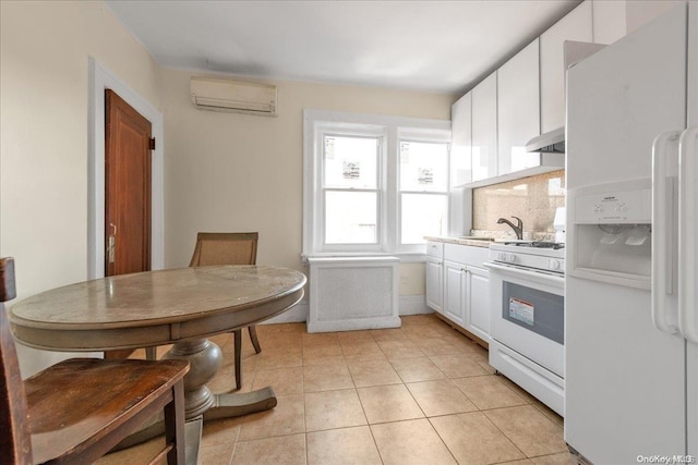 kitchen featuring white appliances, exhaust hood, white cabinets, an AC wall unit, and light tile patterned floors