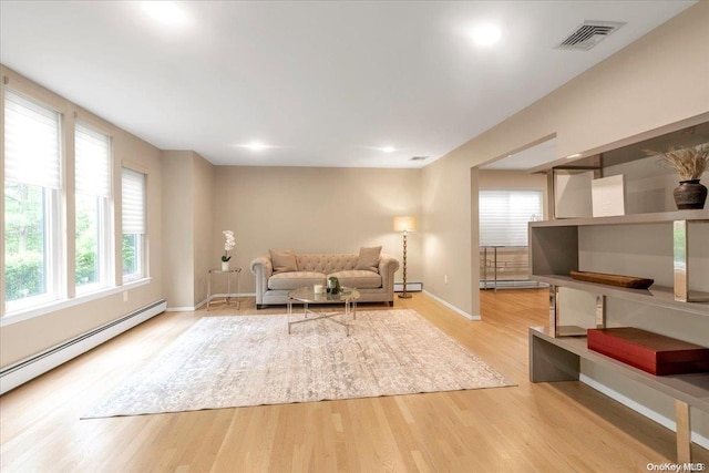 living room featuring light hardwood / wood-style flooring and a baseboard heating unit