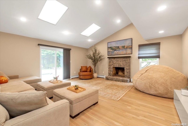 living room featuring light wood-type flooring, a baseboard radiator, a stone fireplace, and lofted ceiling