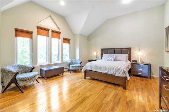 bedroom featuring light wood-type flooring, vaulted ceiling, and baseboard heating