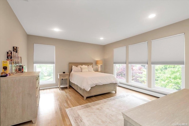 bedroom featuring light hardwood / wood-style flooring and a baseboard heating unit