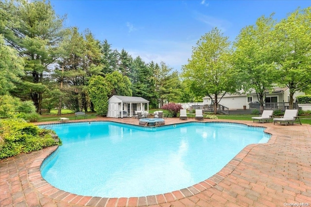 view of swimming pool with a patio and an outdoor structure