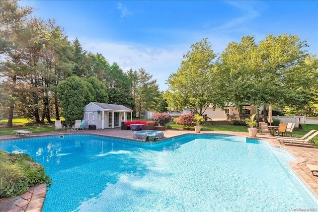 view of pool with an outbuilding and a patio area