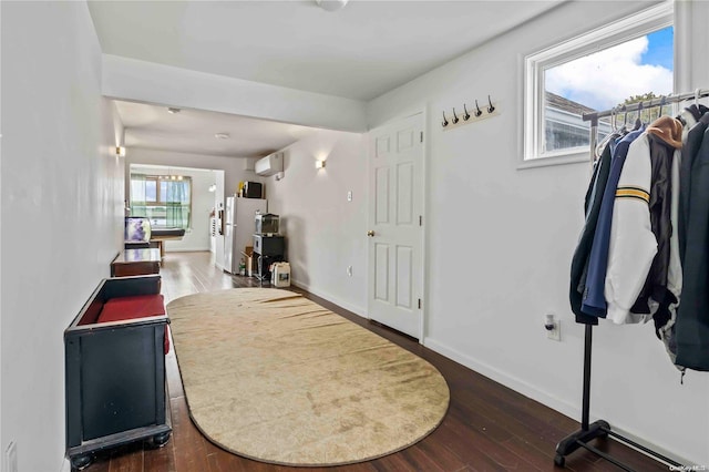 entrance foyer with dark wood-type flooring and a wall mounted air conditioner