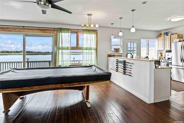 recreation room with a wealth of natural light, a water view, dark hardwood / wood-style floors, and pool table