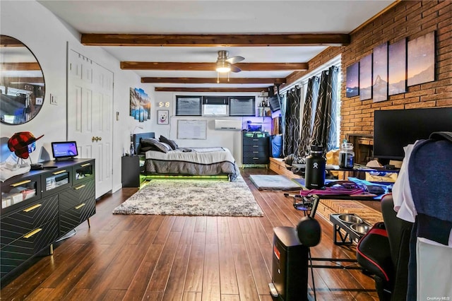 bedroom featuring beamed ceiling, dark hardwood / wood-style flooring, and brick wall