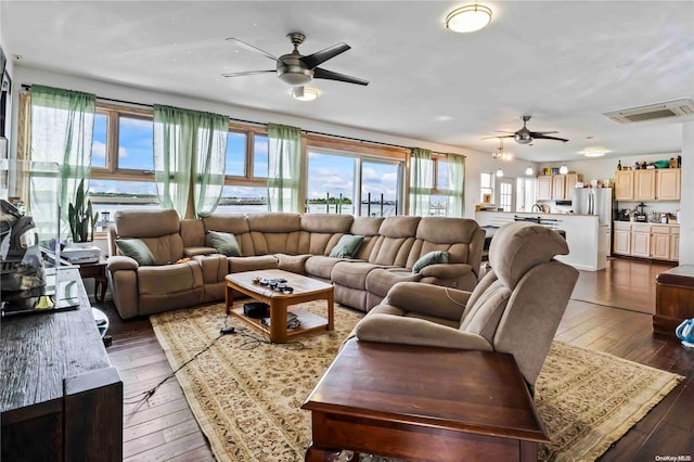 living room featuring dark hardwood / wood-style floors, ceiling fan, and a wealth of natural light