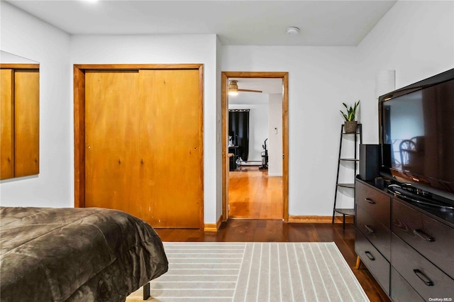 bedroom with dark hardwood / wood-style flooring and a closet