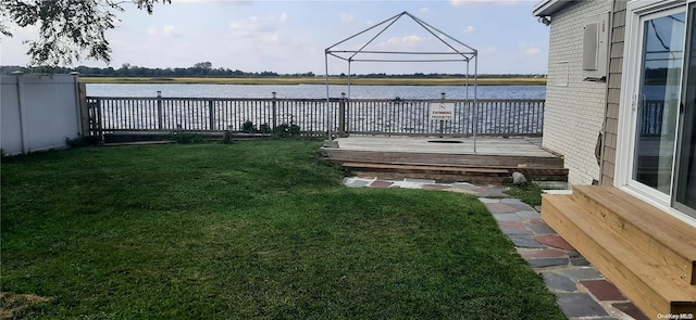 view of dock with a deck with water view and a lawn