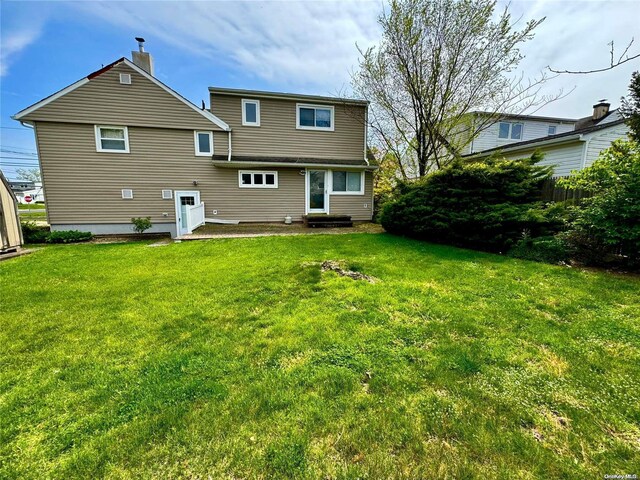 rear view of house featuring a yard