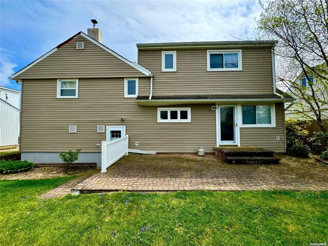 rear view of house featuring a patio area and a lawn