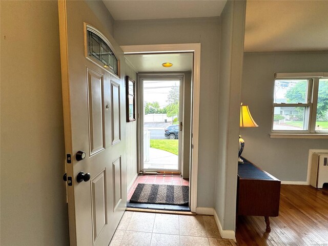 foyer entrance featuring radiator heating unit, light hardwood / wood-style floors, and plenty of natural light