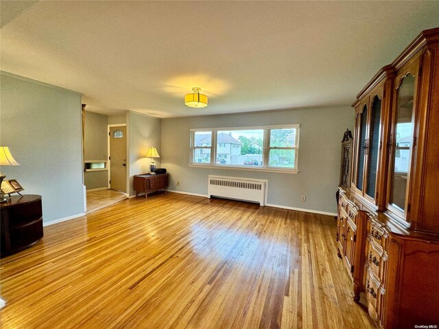 living room with radiator heating unit and light hardwood / wood-style flooring